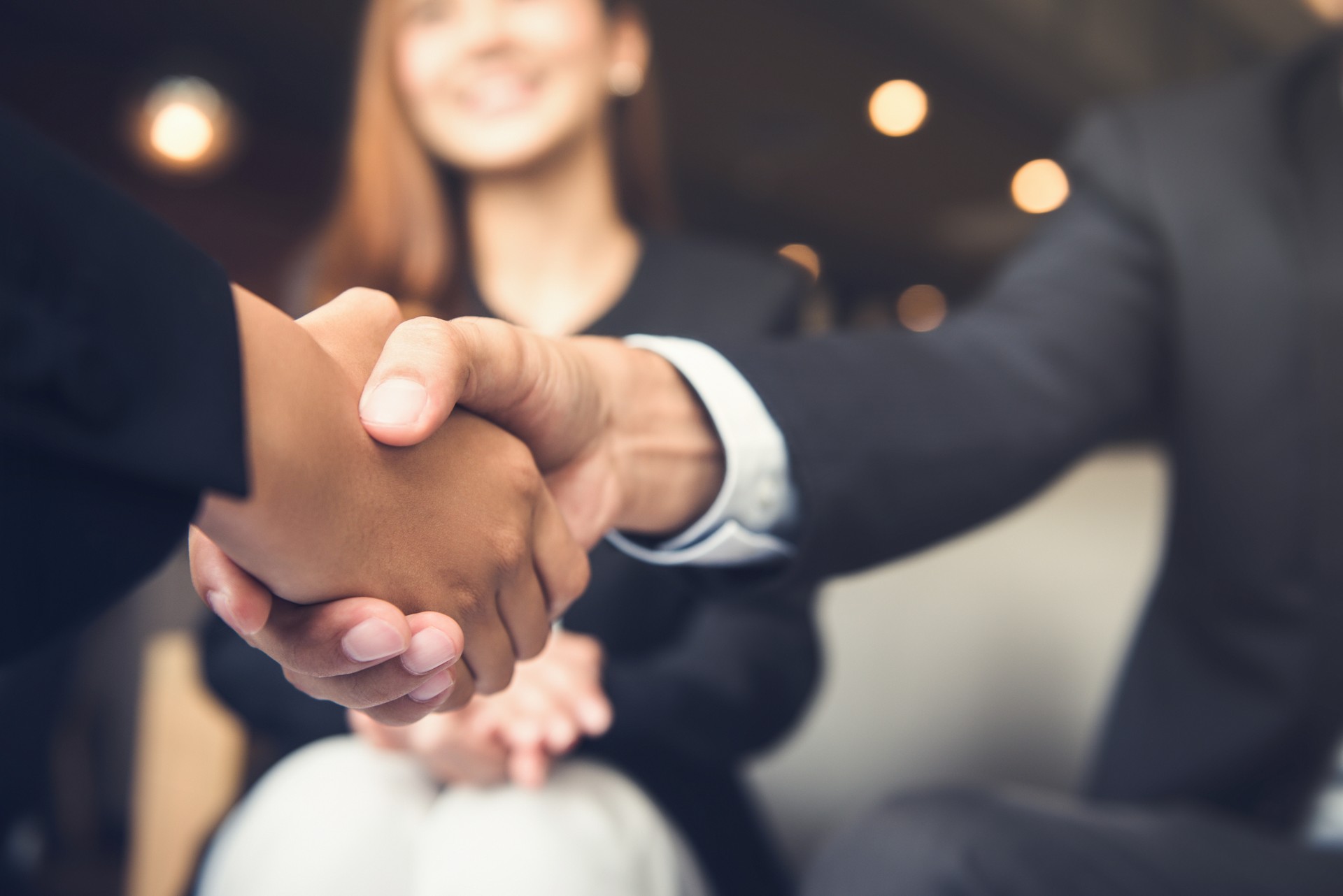 Empresarios estrecharme la mano después de la reunión en un café